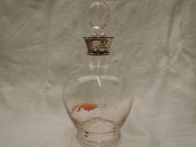 A clear glass spherical decanter on pedestal foot with ball stopper and silver collar, London