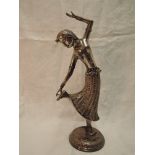 A white metal study of a Far Eastern dancing figurine having moulded and engraved decoration on a