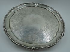 A Victorian silver salver having gadrooned pie crust rim, engraved decoration with central crest and