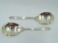 A pair of Georg Jensen Danish silver serving spoons in the Acorn design having plannished bowls
