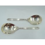 A pair of Georg Jensen Danish silver serving spoons in the Acorn design having plannished bowls