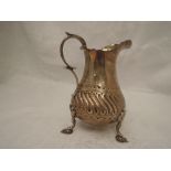 A Victorian silver cream jug of baluster form having moulded decoration, plain cartouche, loop