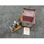 A child's Grain sewing machine in original carrying case with photocopied instructions