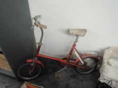 A 1970's Raleigh RSW14 Childs Bicycle in red with white leather seat, pump and bell present