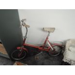 A 1970's Raleigh RSW14 Childs Bicycle in red with white leather seat, pump and bell present