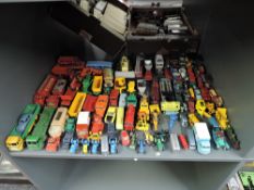 A shelf of playworn diecasts including Corgi Karrier Bantam Milk Van, Dinky Massey Harris Tractor,