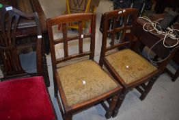 A pair of early to mid 20th Century oak dining chairs