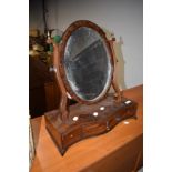 An early 20th Century mahogany toilet mirror having shaped drawer base