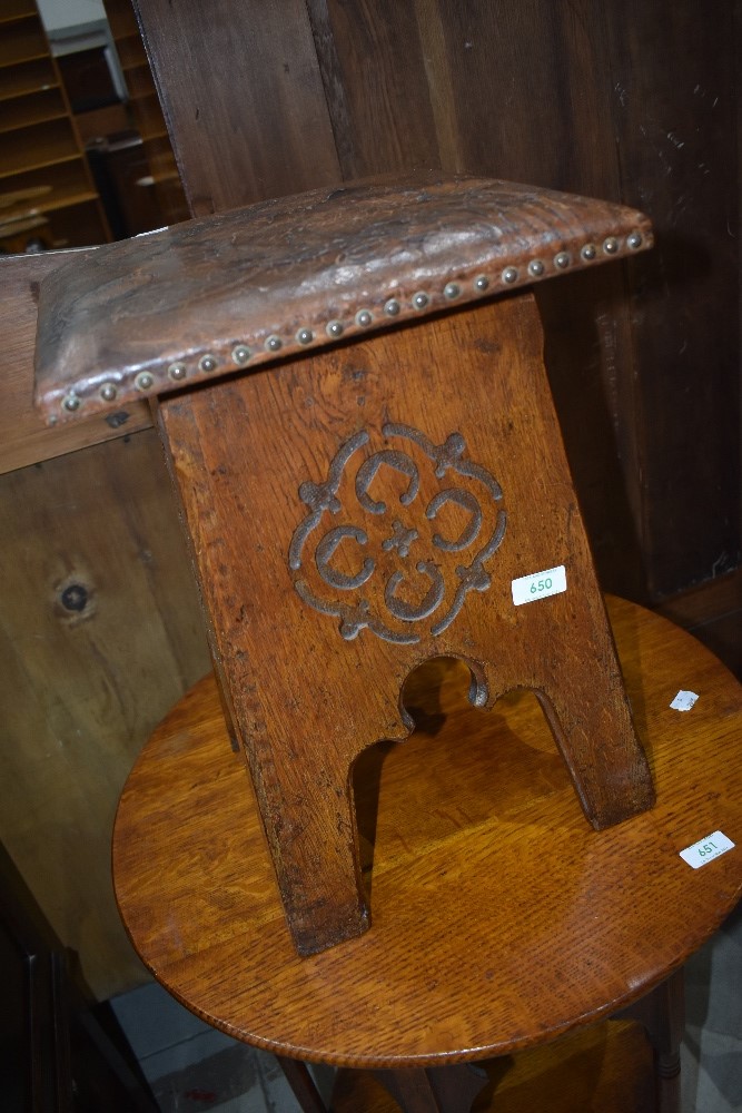 An Arts and Crafts stool, having carved detail and tooled leather top, probably Liberty's