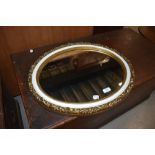 A vintage oval wall mirror, gilt plaster with white trim, width approx 56cm max.