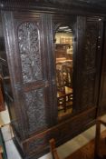 A 19th Century triple wardrobe having central mirror door and heavy carving to doors and double