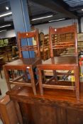 A pair of stained frame solid seat dining chairs having rail and bobbin back