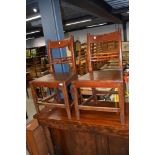 A pair of stained frame solid seat dining chairs having rail and bobbin back