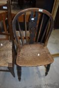 A traditional oak kitchen chair having slat back and turned frame