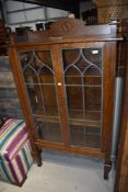 A late 19th or early 20th Century oak display cabinet in the Arts and Crafts style with leaded glass