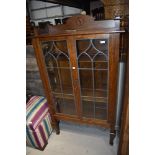 A late 19th or early 20th Century oak display cabinet in the Arts and Crafts style with leaded glass