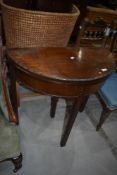 An early 20th Century mahogany demi lune fold over card table