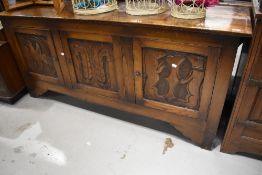 A traditional oak sideboard or dresser base, having carved triple door, width aopprox. 183cm