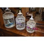 A set of three ornamental bird cages, graduated sizes