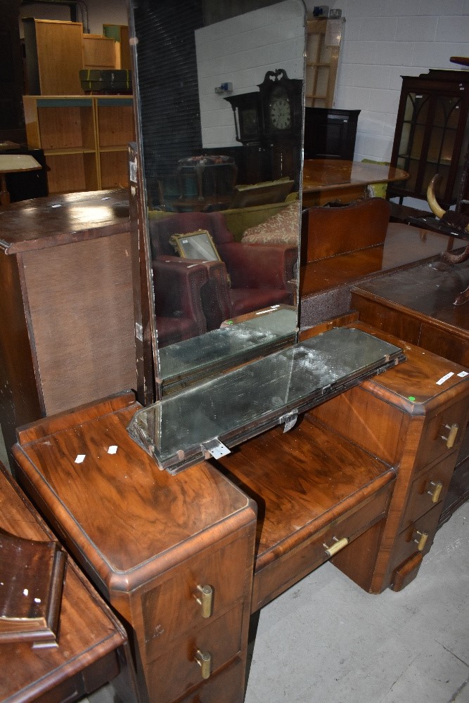 A mid 20th Century walnut dressing table having Art Deco style handles