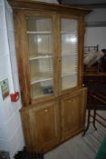 A large stripped pine corner display cabinet