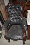 A 19th Century mahogany scroll frame easy chair having green leather button back upholstery