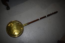 A traditional copper and brass warming pan