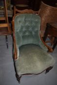 A Victorian low seat armchair having scroll arm and dralon upholstery with button back