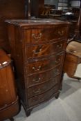 A reproduction Regency style serpentine fronted slender chest of six drawers (plus brushing