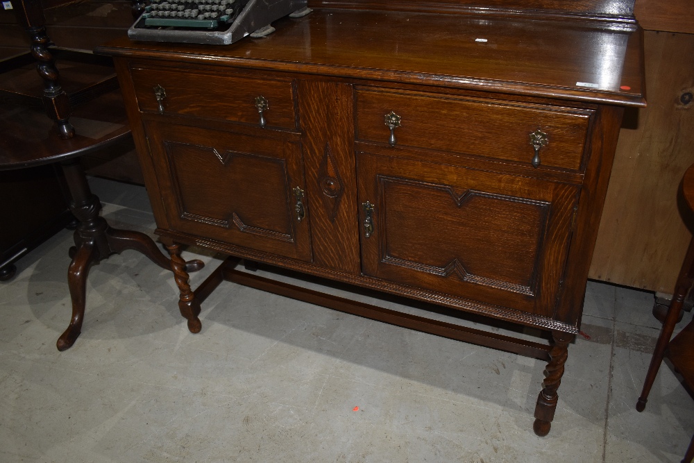 An early 20th Century oak sideboard having twist legs