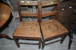 A pair of 19th Century oak solid seat chairs having rail back
