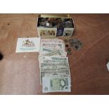 A collection of World Coins and Banknotes in a tin including 26 US Dollar notes, 2 £1 UK notes and