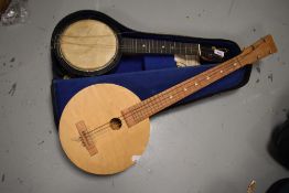 An early 20th Century banjo ukulele, stamped JETEL (number 5), in need of restoration with semi hard