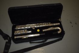 A traditional plated flute , stamped gear for music with additional curved head, in fitted plush