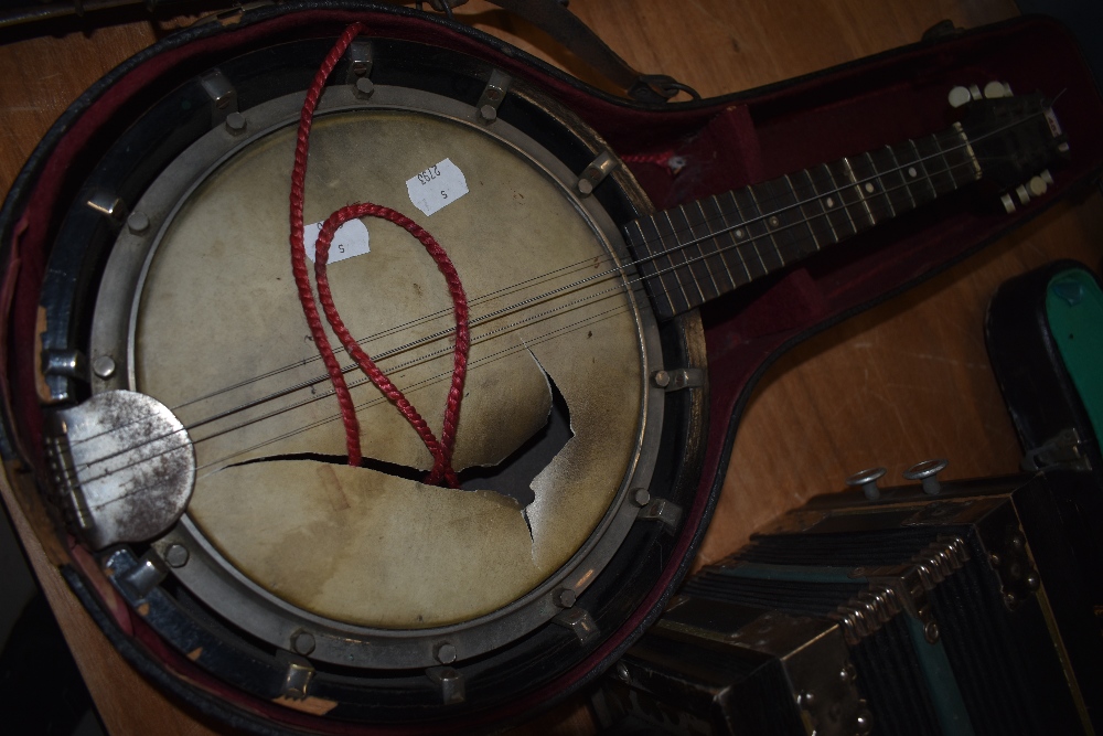 A late 19th or early 20th Century mandolin banjo (af with damage to skin and half case)