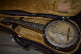 An early 20th Century banjo ukulele in need of some restoration to skin etc, in a violin case