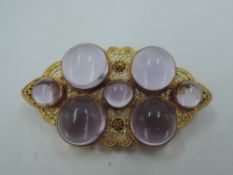 A yellow metal filigree brooch stamped 14K of lozenge form having seven Amethyst cabouchons,