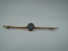 A rose gold bar brooch stamped 9ct having central black opal in collared mount, approx 2g