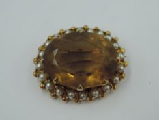 A yellow metal brooch stamped 9ct having citrine style stone with seed pearl surround in coronet
