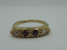A ruby & diamond dress ring in a pave set lozenge shaped mount on a yellow metal loop stamped