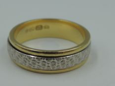 An 18ct white and yellow gold wedding band having mobile moulded central band, size M/N & approx 5.