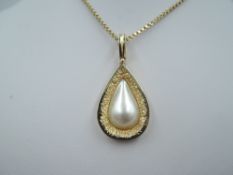A yellow metal pendant stamped 14K having a teardrop shaped pearl panel in gold surround on a yellow