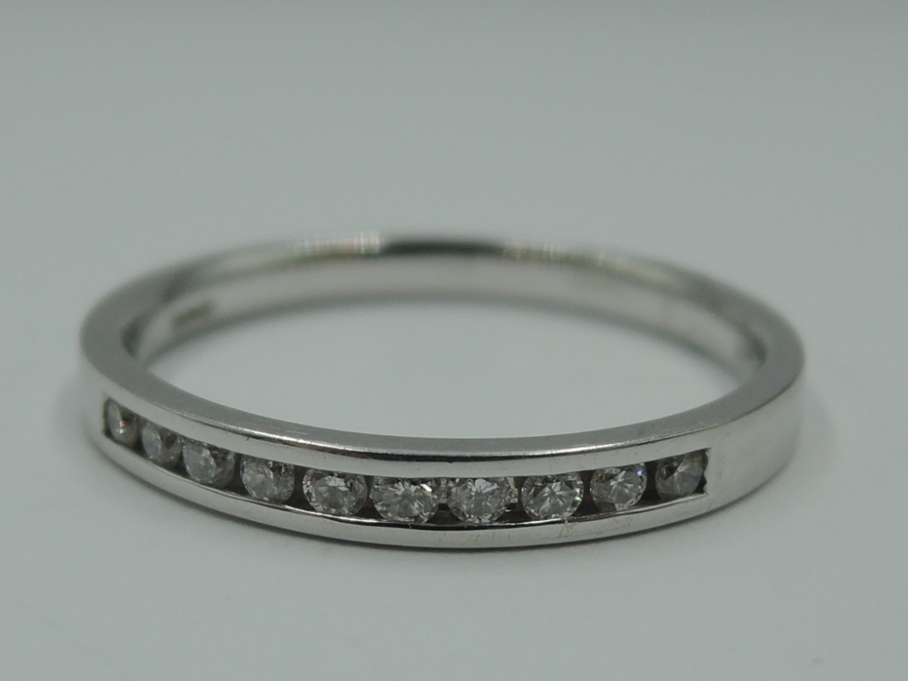 An 18ct white gold half eternity ring having 10 diamond chips in a channel setting, size L &