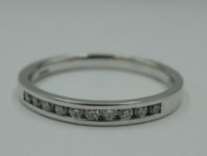An 18ct white gold half eternity ring having 10 diamond chips in a channel setting, size L &