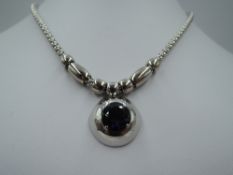 An 18ct white gold amethyst pendant having a single 4ct stone in a moulded semi circle mount on an