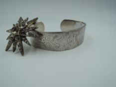 A silver cuff bangle by Charles Horner having engraved Aztec style decoration, Chester 1943, Charles