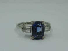 A 1930's dress ring having a central cushion cut sapphire, approx 1.65ct flanked by two baguette cut