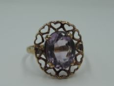 An amethyst dress ring within a heart patterned mount on a 9ct gold loop, size M & approx 2.7g