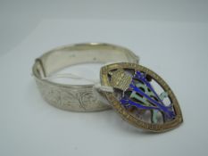 A silver hinged bangle having engraved decoration and concealed slide clasp, and a silver 21 years