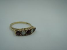 A garnet and opal dress ring in a claw set scrolled gallery mount on a 9ct gold loop, size R &